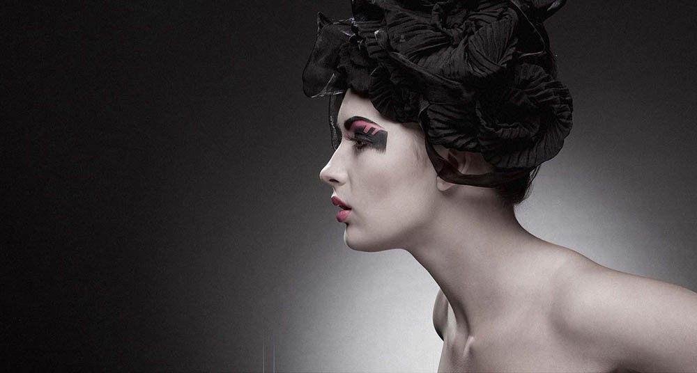 Avant-garde hair and makeup editorial look with sculpted black headpiece